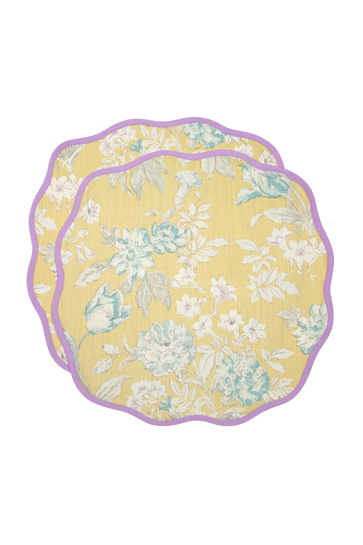 A set of two round placemats with a floral pattern in yellow, white, and green colors, with a scalloped edge and purple trim.