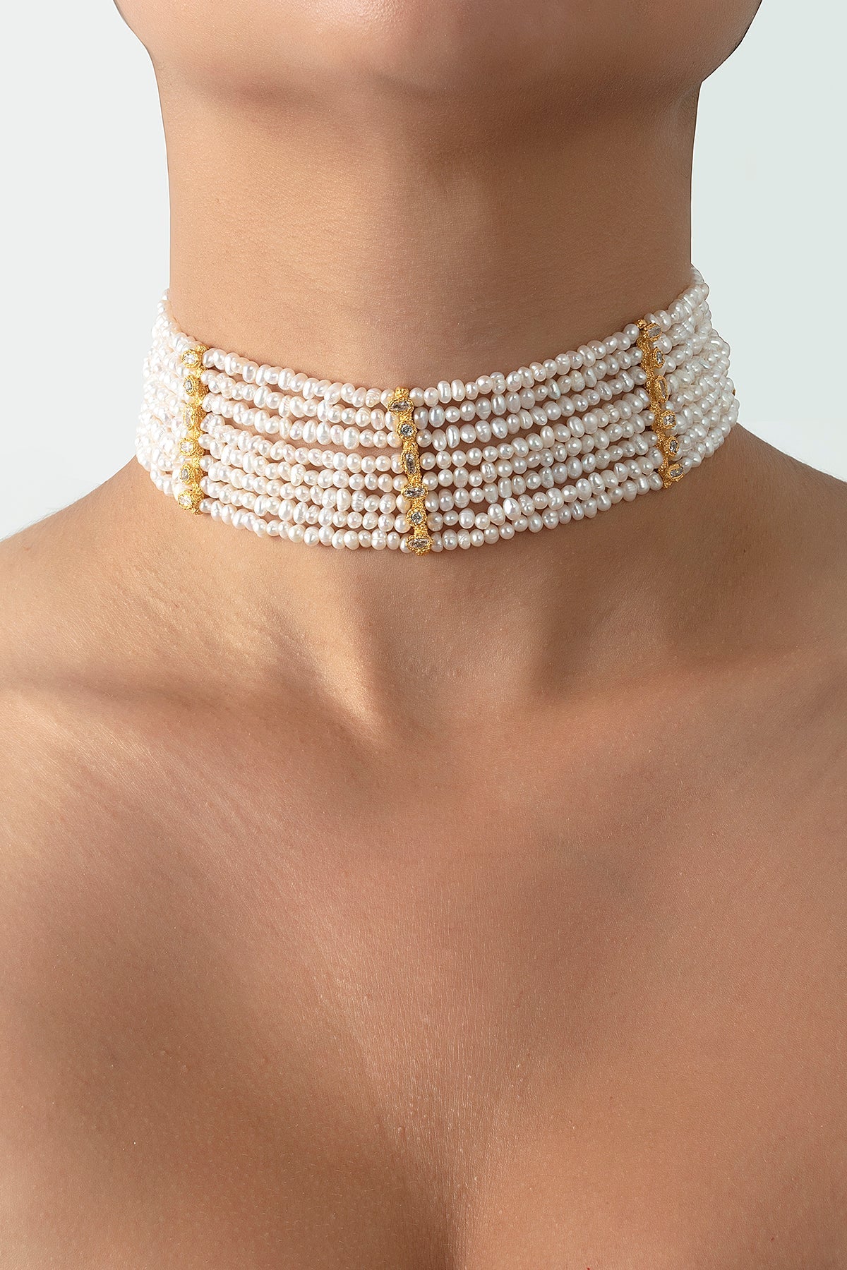 Pearl choker necklace on a person against a neutral background