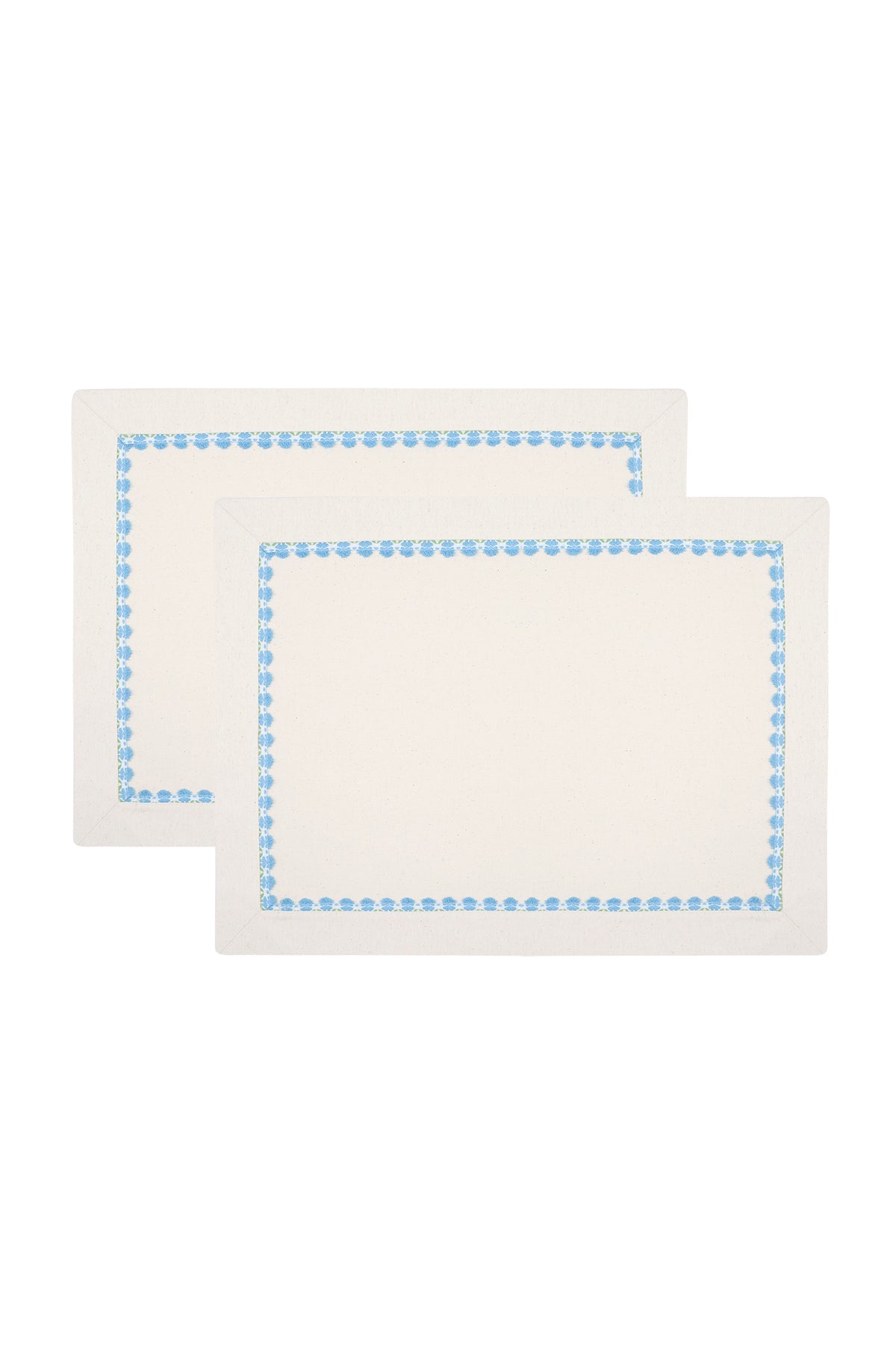Two rectangular white placemats with a blue dotted border laid one over the other.