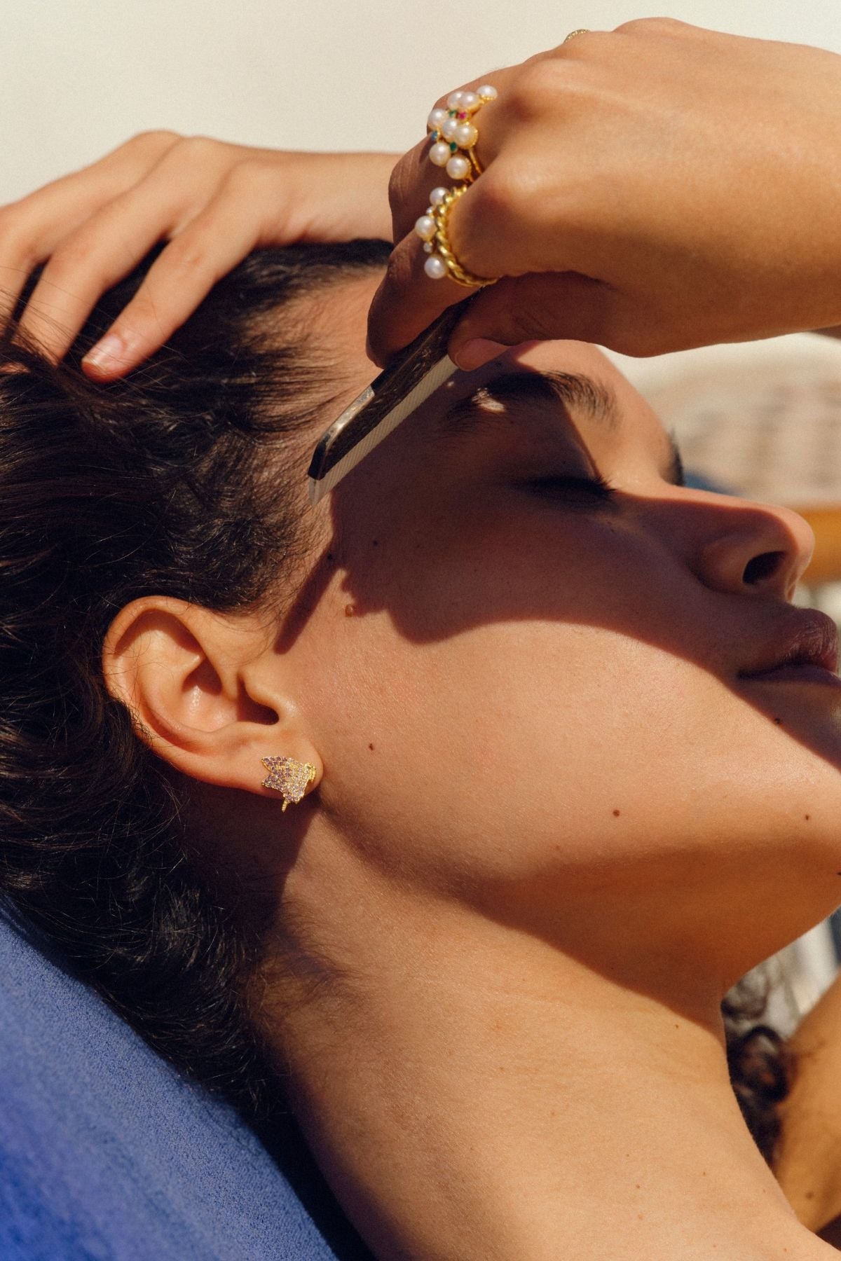 Close-up of a person getting their hair cut by another person outdoors.