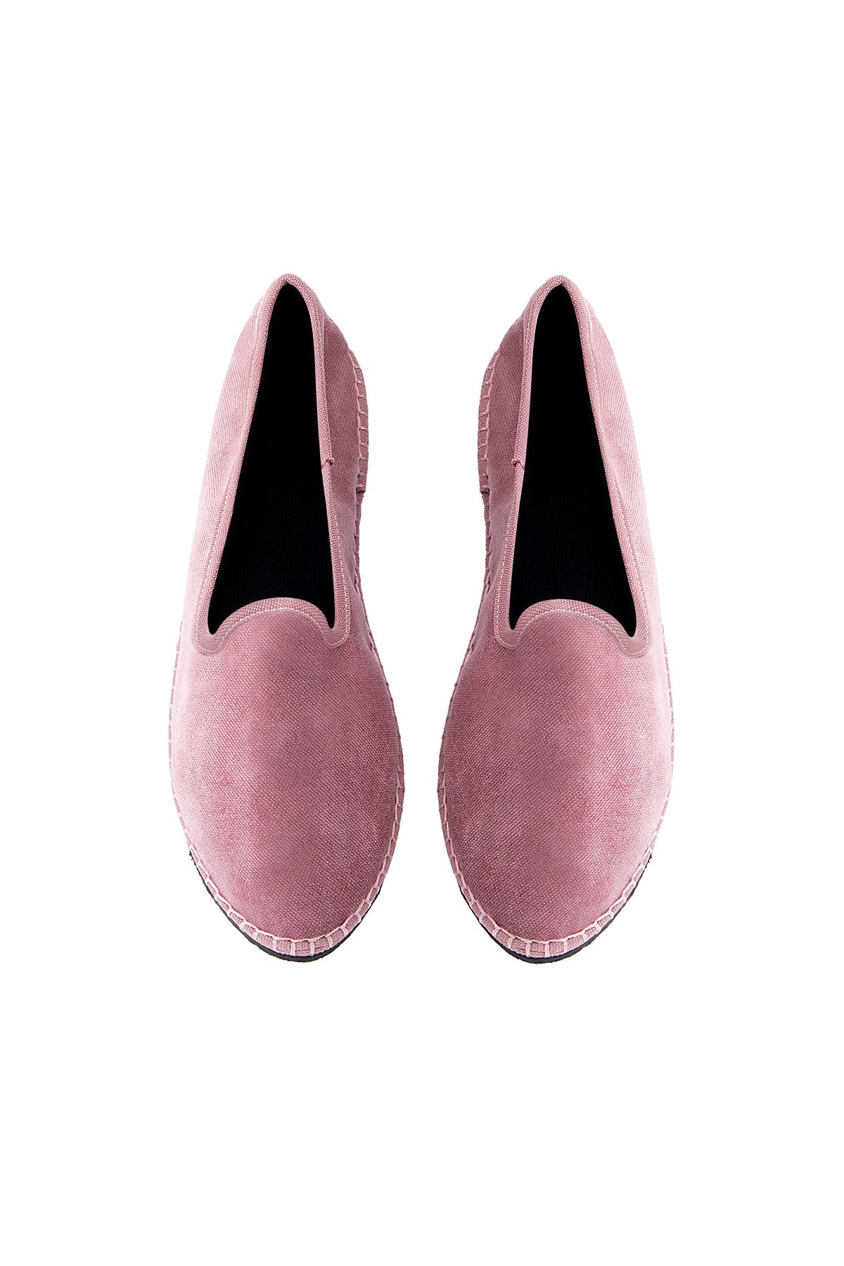 Pair of pink velvet loafers on a white background