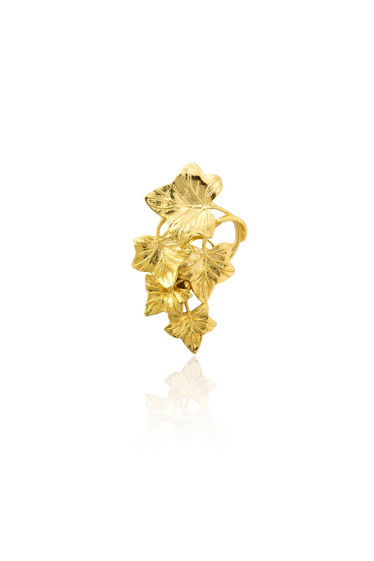 A gold-colored hair clip with a leaf pattern on a white background.