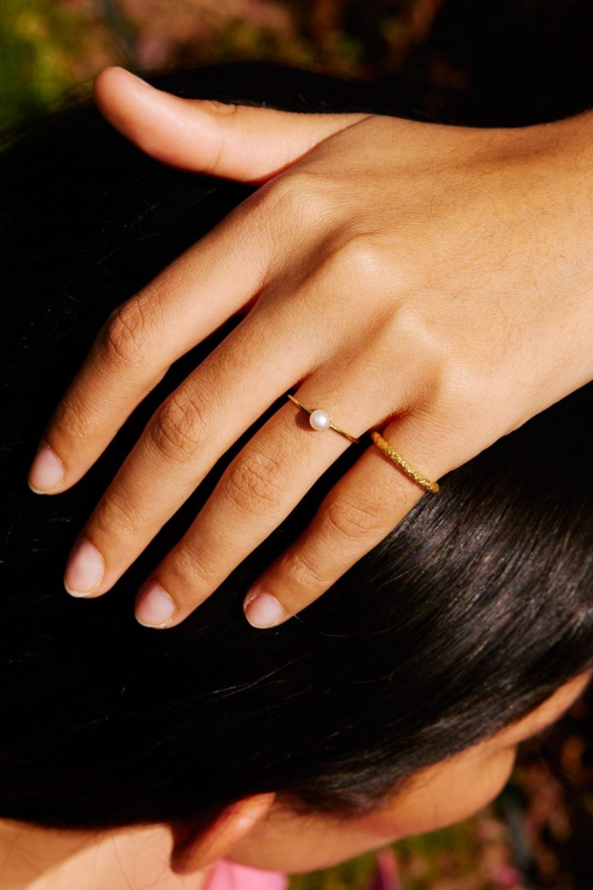 Close-up of a hand with a ring on a blurred background
