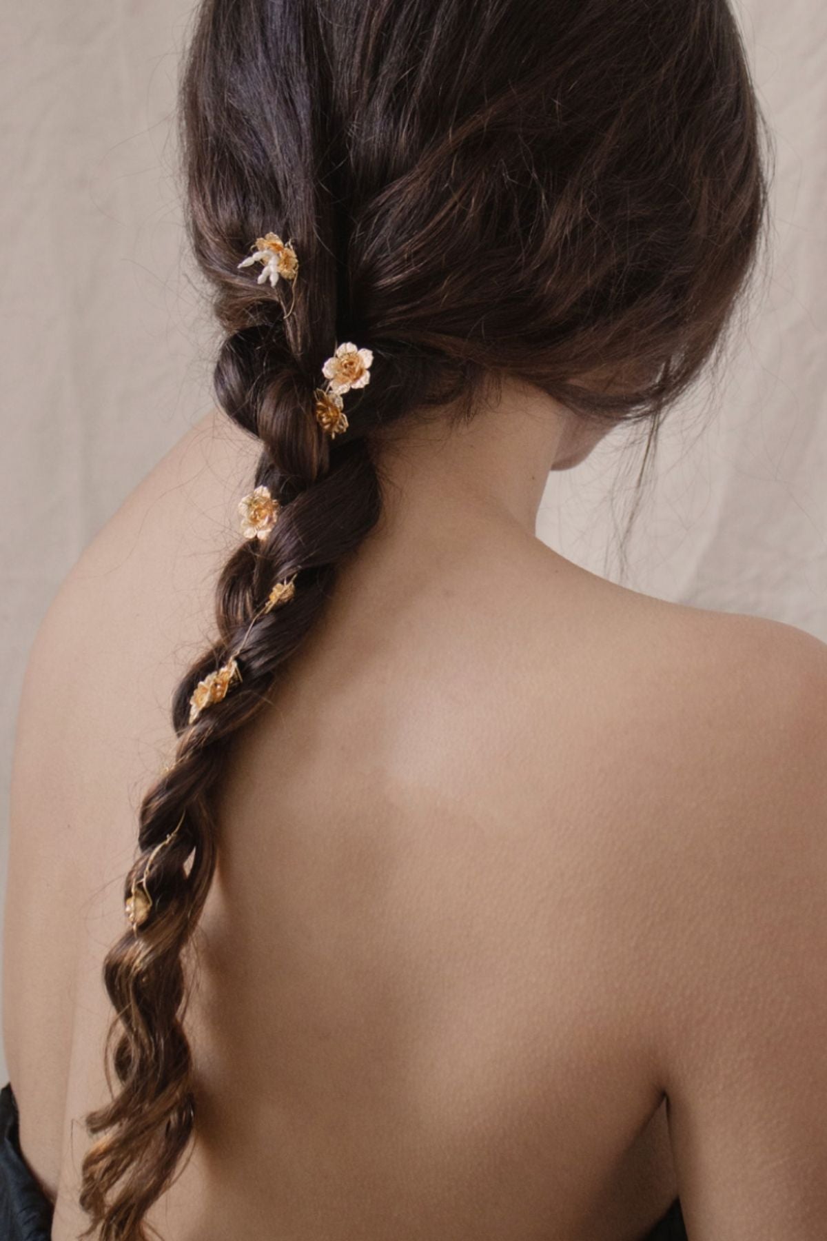 Braided hair with floral hairpins on a neutral background