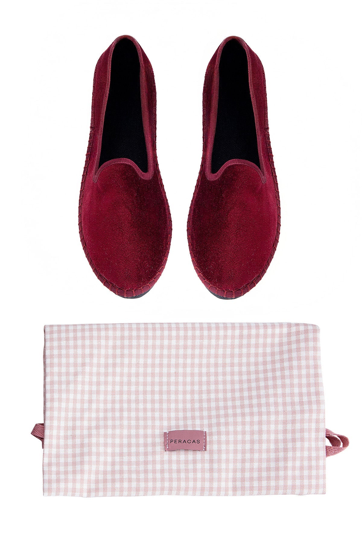 Pair of red slippers with a matching gingham-patterned pouch on a white background
